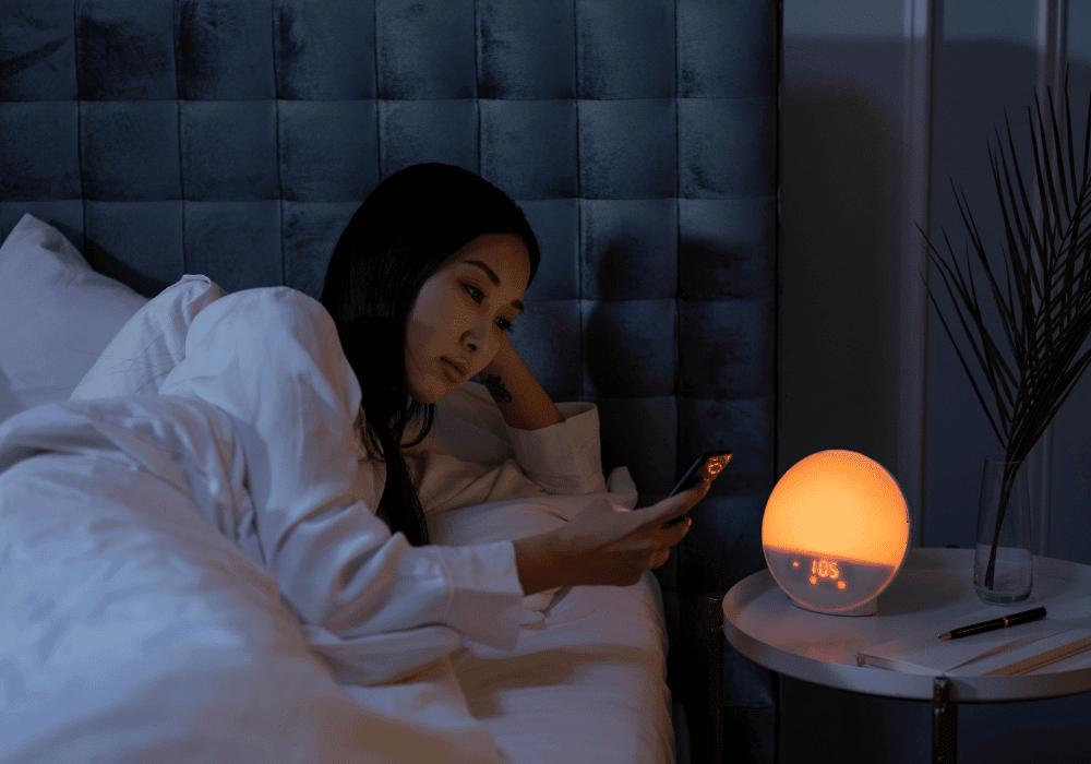 夜に一人でスマホを見つめる40代女性